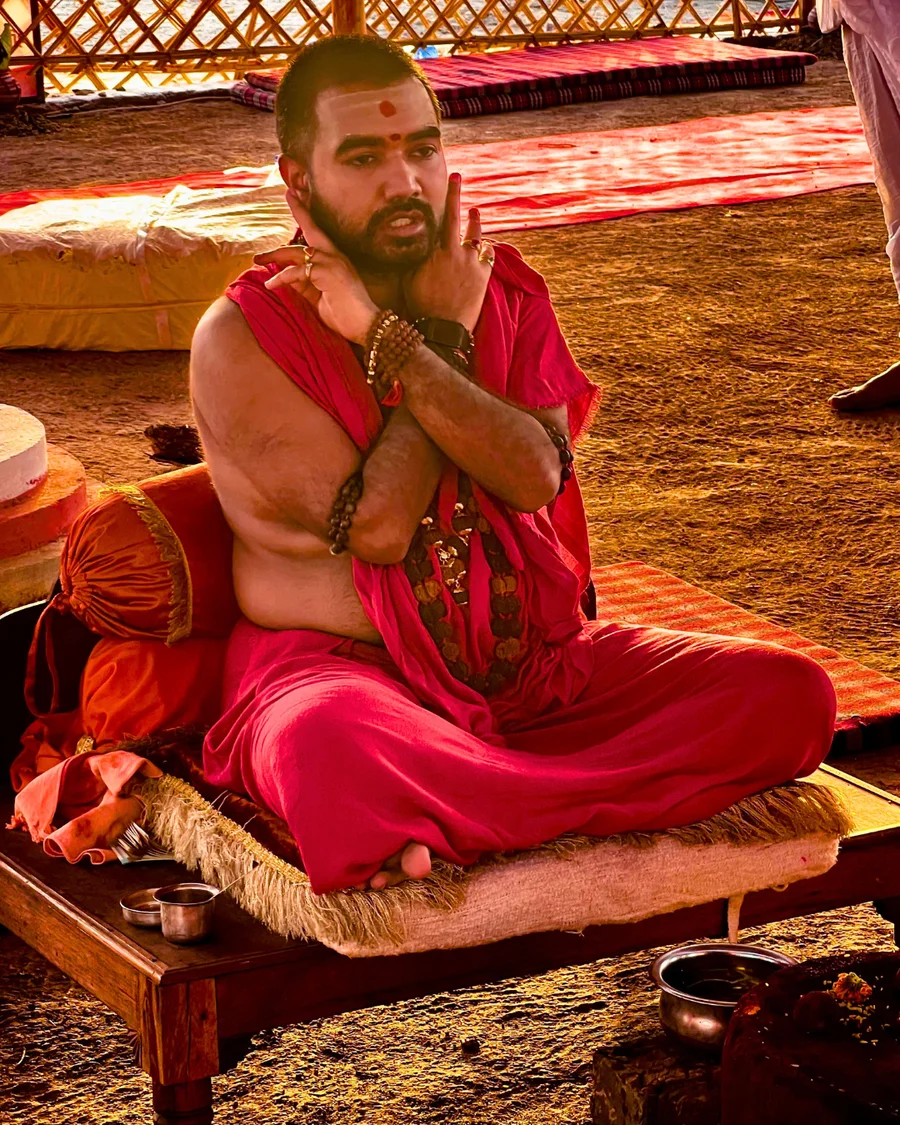 Param Pujya Mahamandaleshwar Shree Swami Avatar Puri Ji Maharaj with arms crossed during the fire ritual.